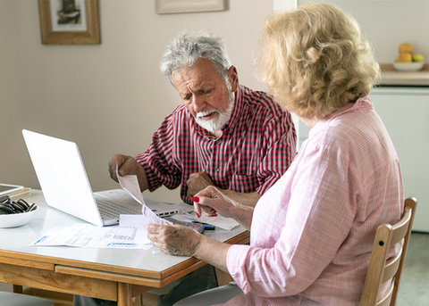 Een ouder stel neemt de administratie door aan de keukentafel